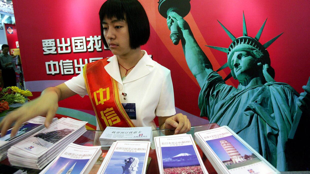 Девушка у стенда китайской компании CITIC на Международной выставке финансовой культуры в Пекине, КНР